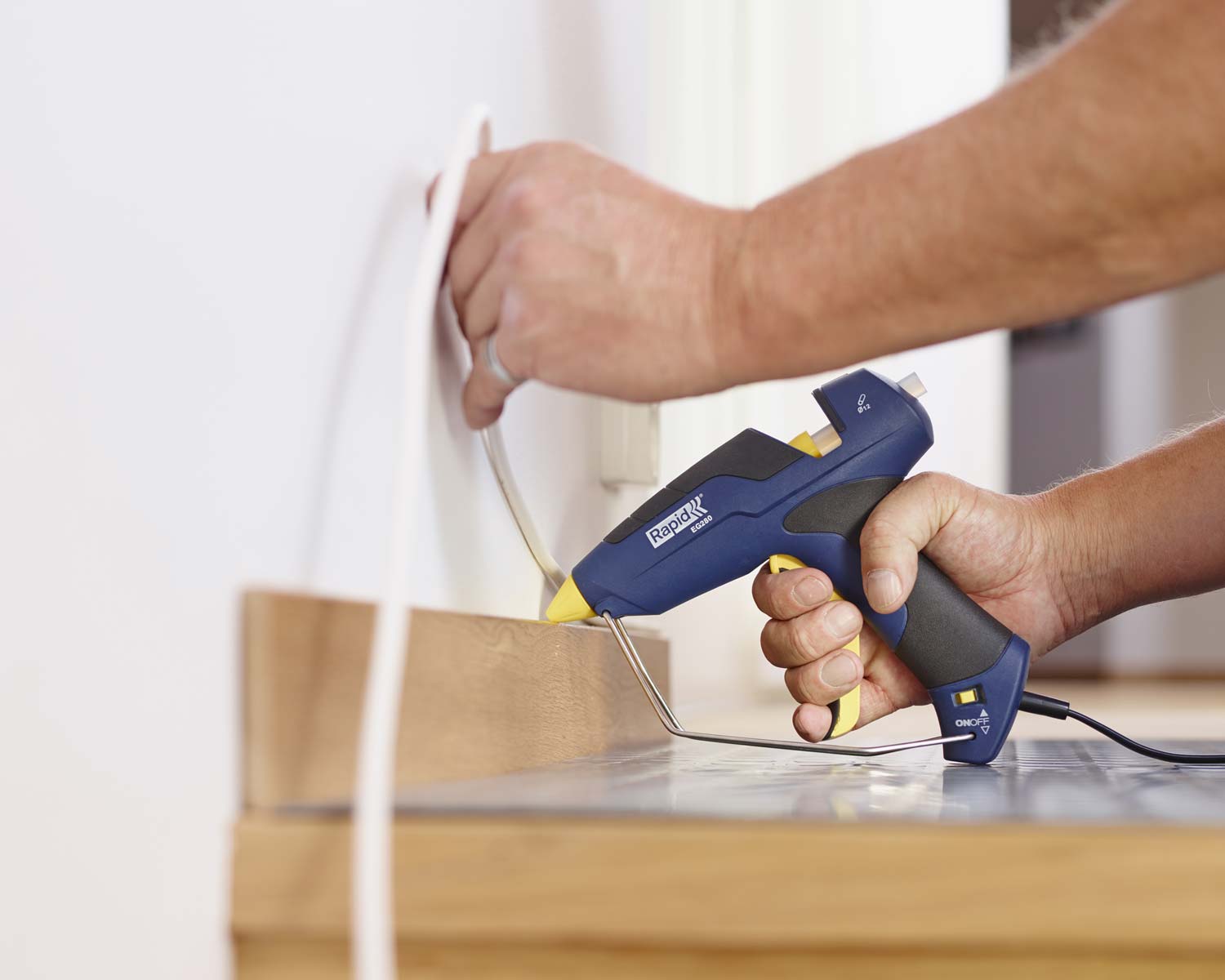Hot melt glue gun to fix cable to the wall