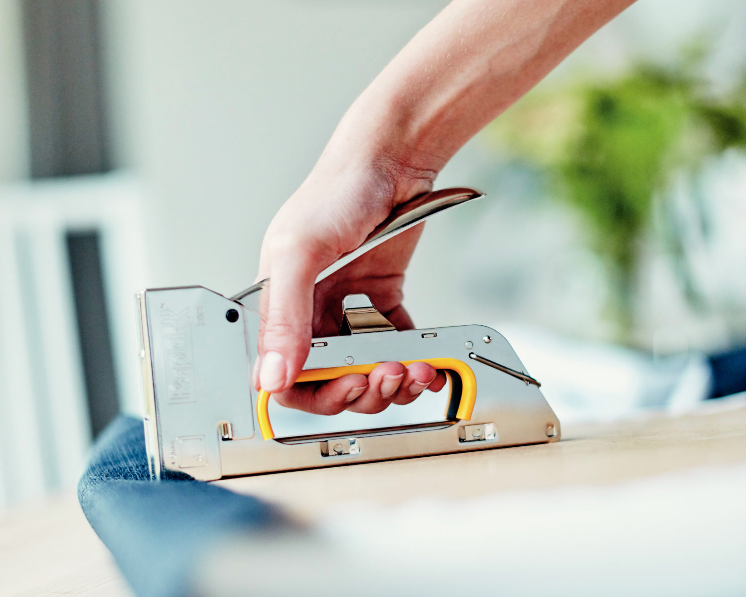 A manual staple gun used for furniture upholstery